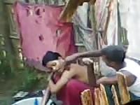 Woman washing outdoors gets help from a man